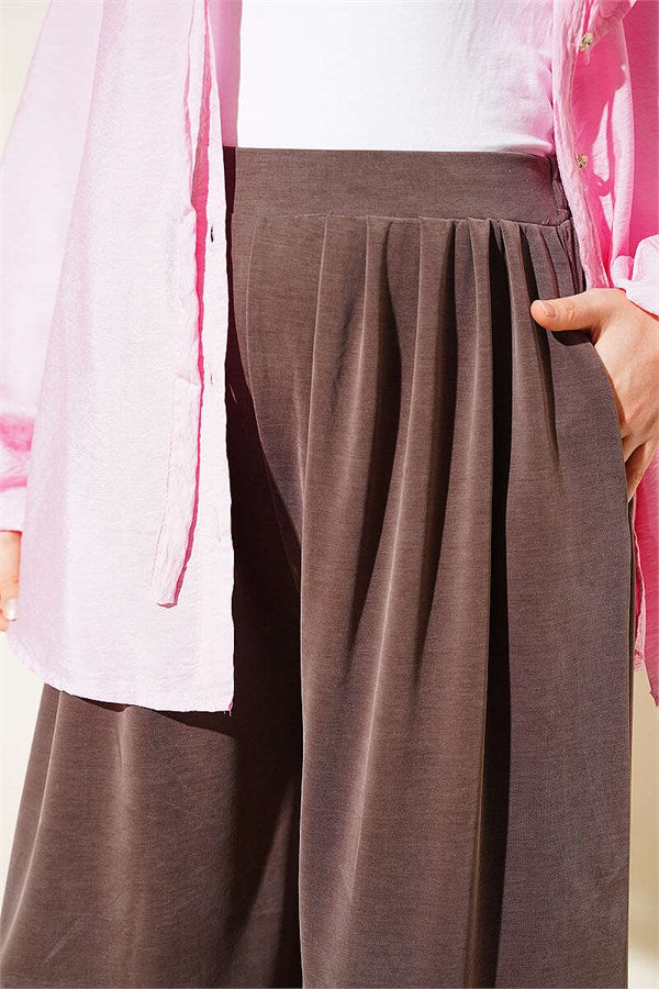 Mink-colored trousers with elasticated waist and pleated details.