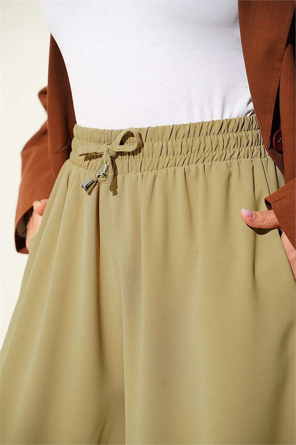 Loose-fitting trousers with elastic waistband, olive green.