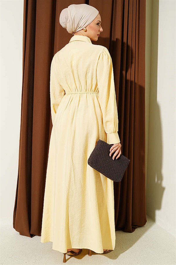 Waist-fitting half-buttoned dress in yellow.