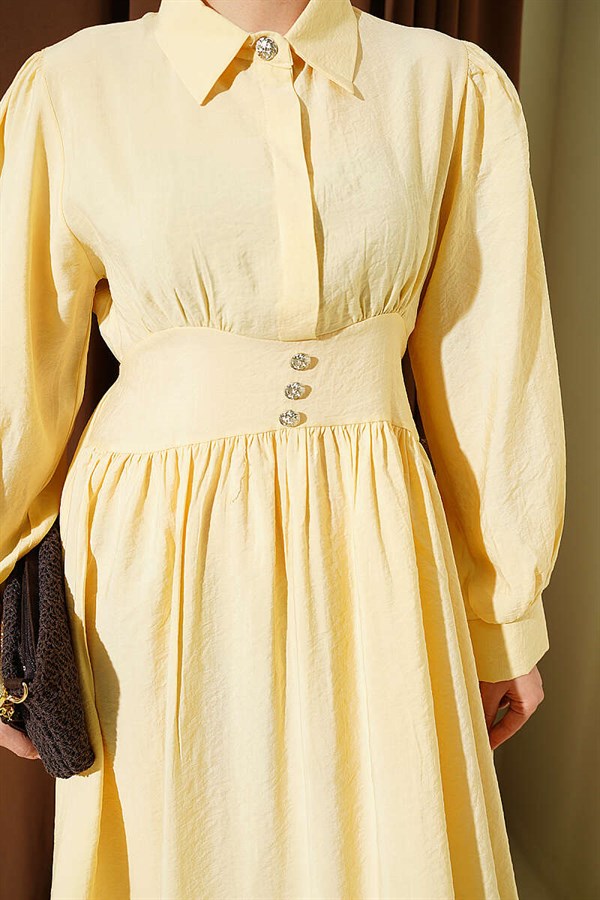 Waist-fitting half-buttoned dress in yellow.