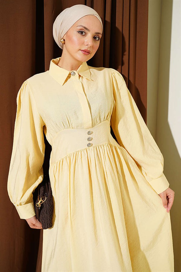 Waist-fitting half-buttoned dress in yellow.