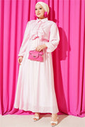 Two-piece set in pink with gold button detail and ruffled skirt.