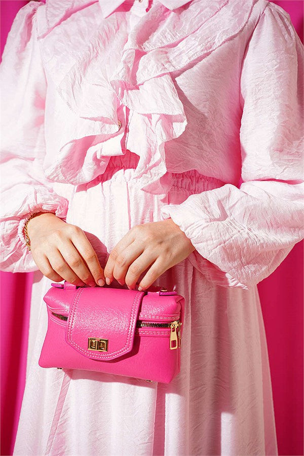 Two-piece set in pink with gold button detail and ruffled skirt.