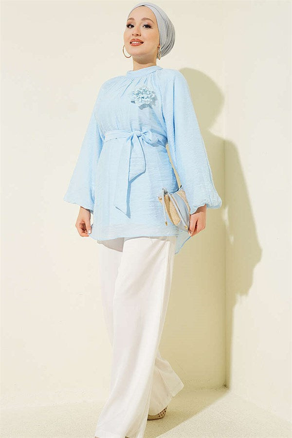 Self-belted tunic with rose brooch, ice blue.