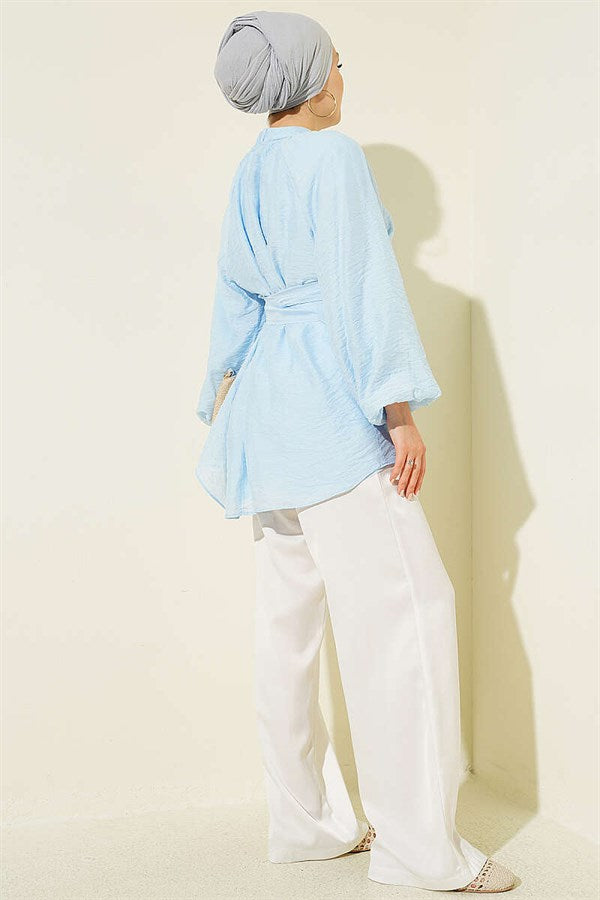 Self-belted tunic with rose brooch, ice blue.