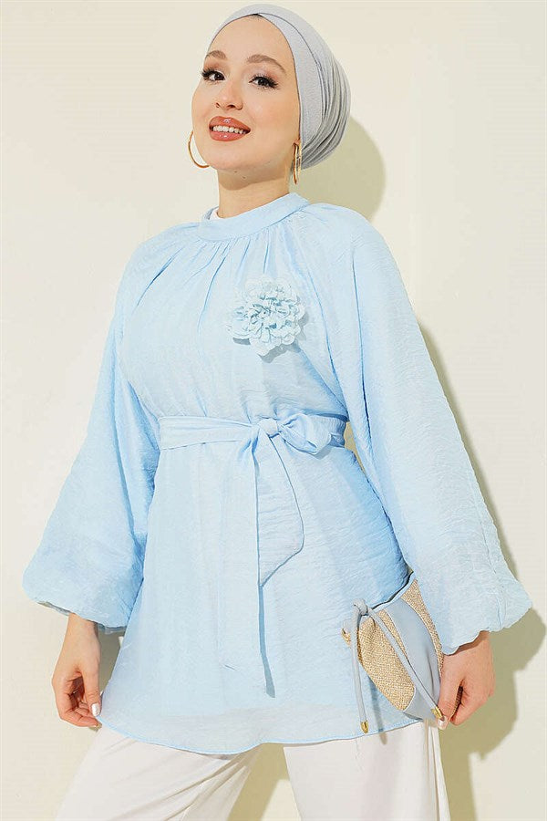 Self-belted tunic with rose brooch, ice blue.