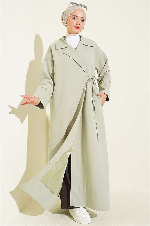 Double-breasted trench coat with drawstring closure, light green.