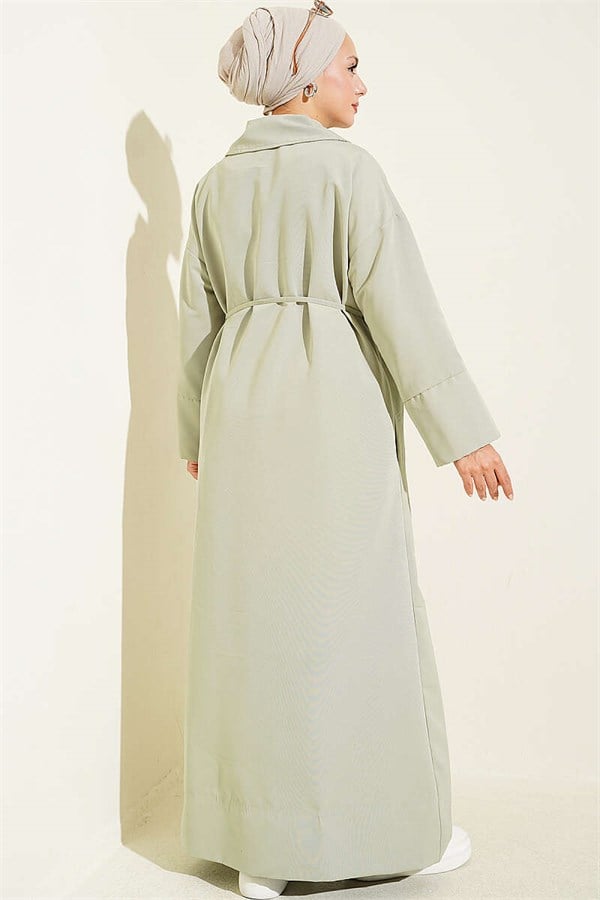 Double-breasted trench coat with drawstring closure, light green.