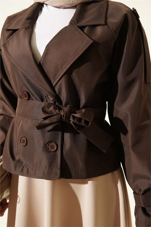 Double-breasted belted short trench coat in brown.