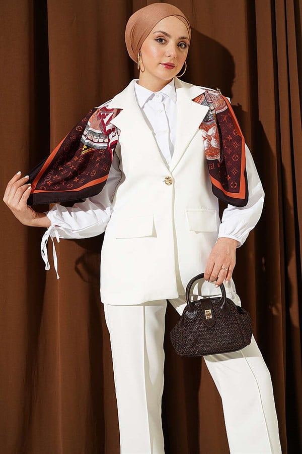Off-white suit with shoulder epaulets and gold buttons.