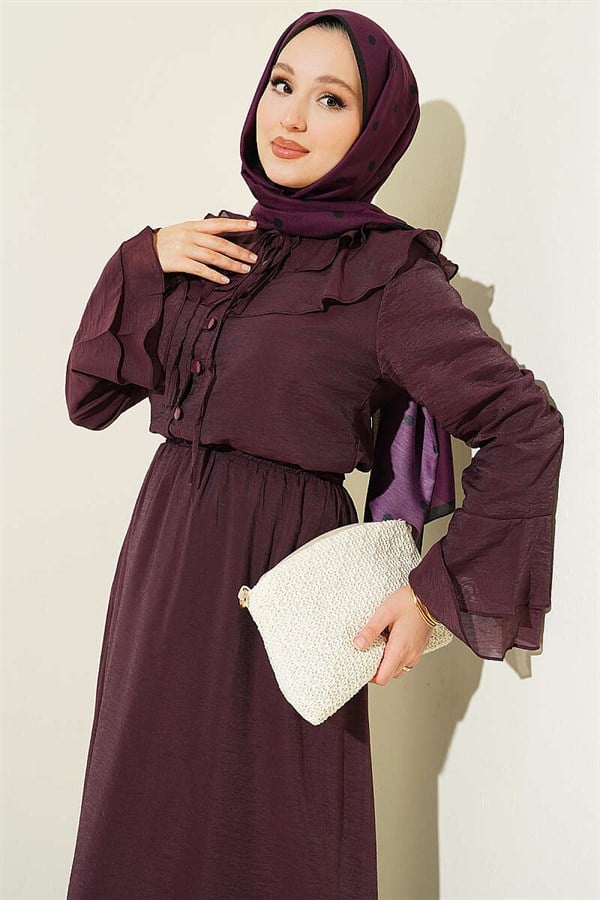 Plum-colored suit with ruffled collar and British-style button-down skirt.